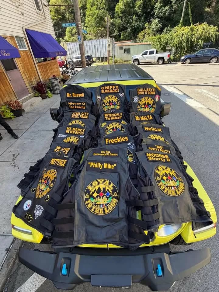 Black vests arranged across a vehicle, displaying Loyal to the Logo back emblems.